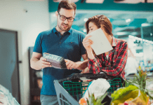 A couple using a list while grocery shopping.