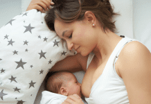 A woman laying down while breastfeeding a baby.