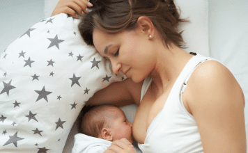 A woman laying down while breastfeeding a baby.