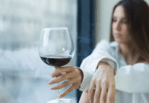 A woman drinking a glass of wine.
