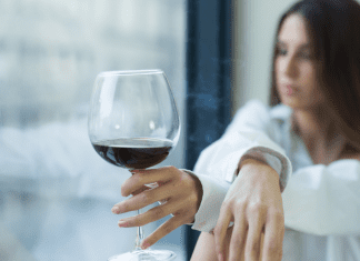 A woman drinking a glass of wine.