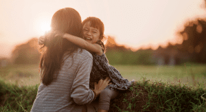 A child hugging a mom.