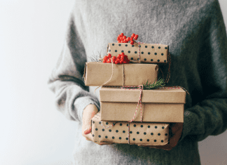Woman holding wrapped holiday gifts.