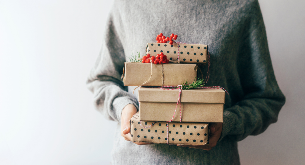 Woman holding wrapped holiday gifts.