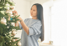 A woman decorating a Christmas tree.