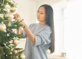 A woman decorating a Christmas tree.