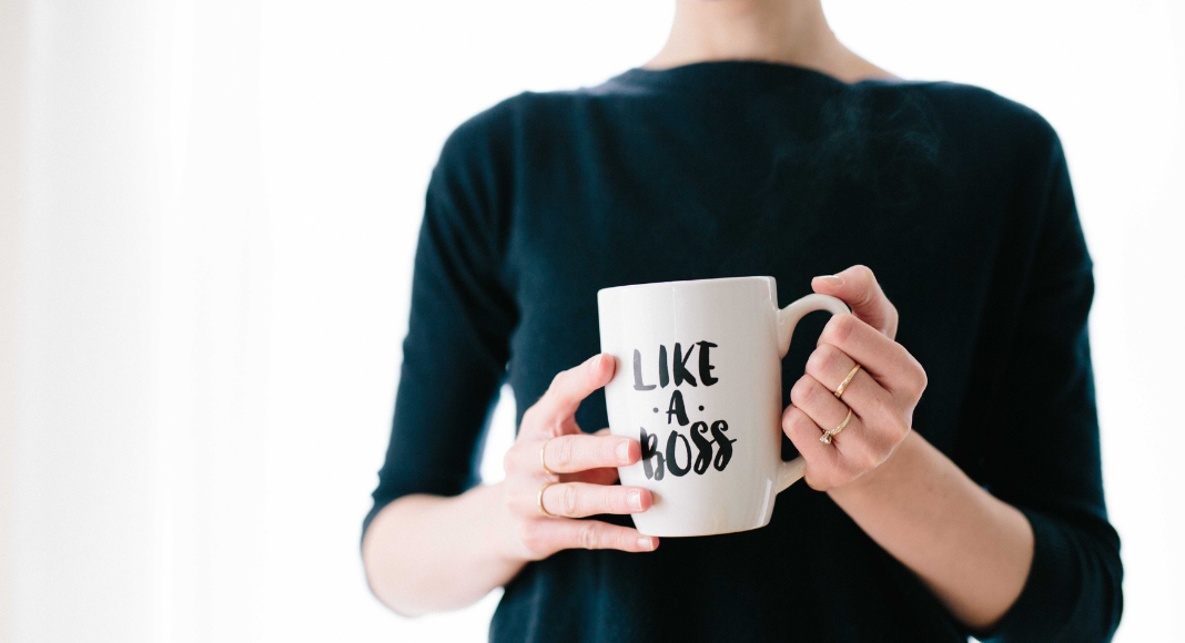 A woman holding a mug that says "Like a Boss."
