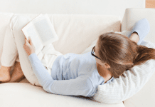 A woman on the couch reading.
