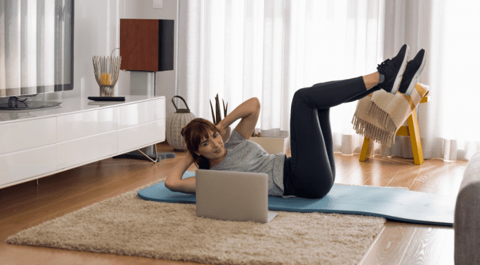 A woman doing an at-home workout in her living room.