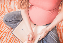 A pregnant woman writing a birth plan.
