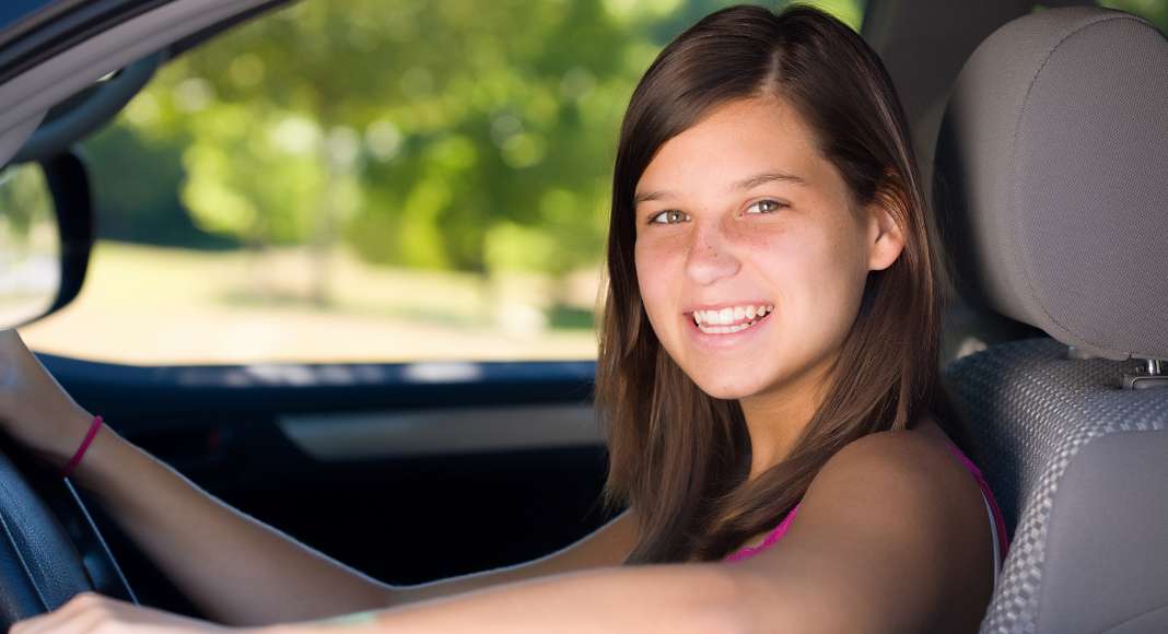 A teen driving a car.