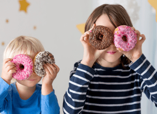 Kids holding doughnuts over their eyes.