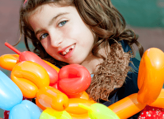 A girl holding a bunch of balloon animals.