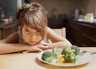 A girl refusing to eat her vegetables.