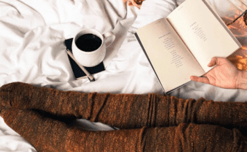 Resting in bed with a book and coffee.