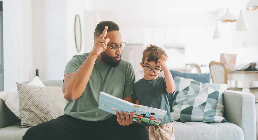 A dad reading a book to his son.